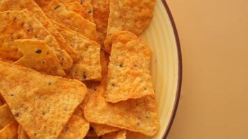 Bowl with tasty potato chips on wooden background . video