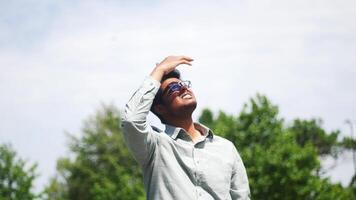 young man covering her face to block sun light. video