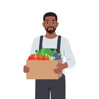 Young man farmer or gardener holds basket of ripe vegetables and fruits. Work and harvest. vector