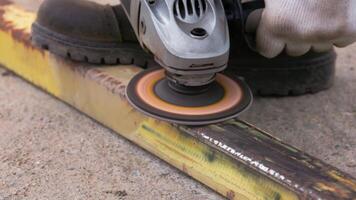 yellow rusted square steel pipe is being cleaned with angle grinder and flap disc video