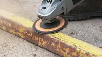 yellow rusted square steel pipe is being cleaned with angle grinder and flap disc video