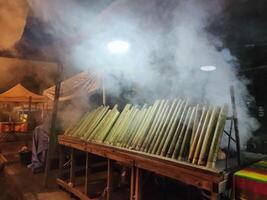 Malaysia's Lemang, a seasonal delight, blends glutinous rice, coconut milk, roasted in bamboo lined with banana leaves. A cherished tradition sold by street hawkers. photo