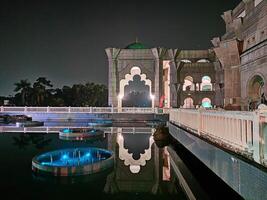 el masjid wilayah persekutuan mezquita en kuala lumpur tiene un hermosa piscina ese es particularmente maravilloso a noche debido a sus reflexión puntos de vista. foto