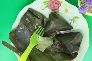 Legendary Malaysian recipe featuring fish, coconut shreds, and chili, wrapped in banana leaves, and steamed. Served at hawker stalls for meals or breakfast. photo