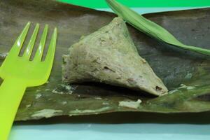 Legendary Malaysian recipe featuring fish, coconut shreds, and chili, wrapped in banana leaves, and steamed. Served at hawker stalls for meals or breakfast. photo