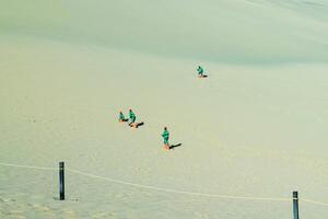 Tiny Human Figures on a Vast Dune photo