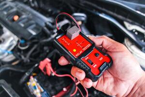 Car relay testing with a relay tester , relay tester in a mechanic hand for system test , Car maintenance and repair servicing concept photo