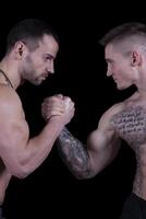 Arm wrestling. Two strong bodybuilders shake hands photo