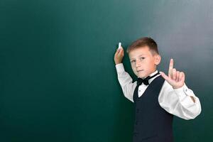 Happy cute clever boy with a bow tie and in glasses had an idea. First time to school. Back to school. photo