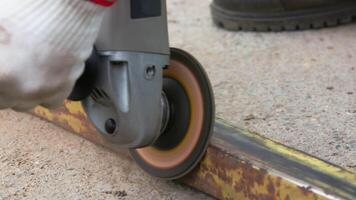 yellow rusted square steel pipe is being cleaned with angle grinder and flap disc video