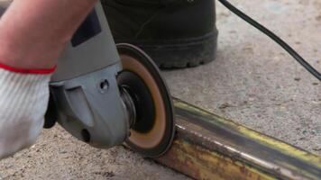 yellow rusted square steel pipe is being cleaned with angle grinder and flap disc video