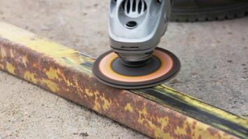 yellow rusted square steel pipe is being cleaned with angle grinder and flap disc video