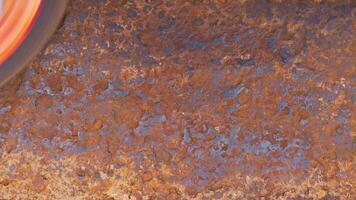 rusted metal surface is being cleaned with angle grinder and a flap disc, full-frame closeup video