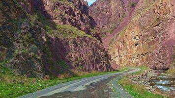 Driving off road rock mountain in gorge of Dzhartash river in Kyrgyzstan at sunny spring day. video