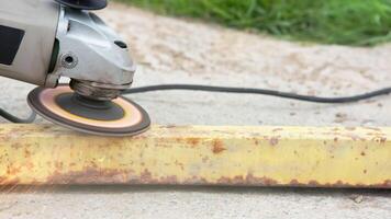 yellow rusted square steel pipe is being cleaned with angle grinder and flap disc video