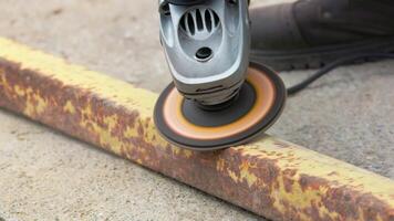 yellow rusted square steel pipe is being cleaned with angle grinder and flap disc video