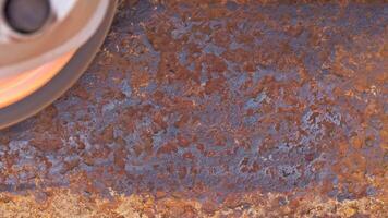 rusted metal surface is being cleaned with angle grinder and a flap disc, full-frame closeup video