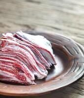 Portion of red velvet crepe cake on the wooden table photo