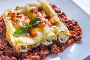 Canelloni stuffed with ricotta with bolognese sauce photo