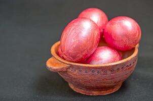 Colorful eggs in clay bowl photo