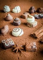 Luxury chocolate candies with cocoa background photo