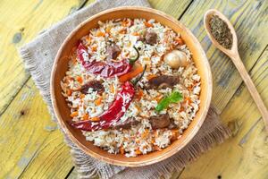 Bowl of pilaf on the wooden table photo