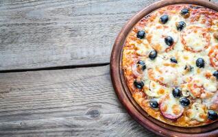 Cooked pizza on the wooden board photo