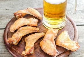 Smoked chicken wings with spicy sauce and glass of beer photo