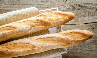 Two baguettes on the wooden tray photo