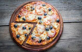 Cooked pizza on the wooden board photo