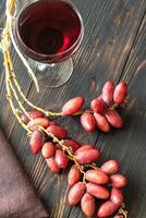 Glass of red wine with bunch of dates photo