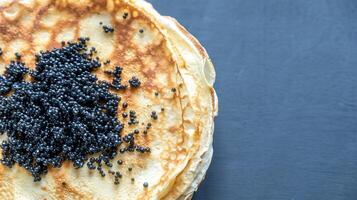 Pile of crepes with black caviar photo