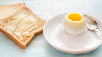 Boiled egg with crispy toasts on the wooden table photo
