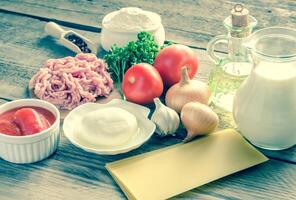 Ingredients for lasagne on the wooden background photo
