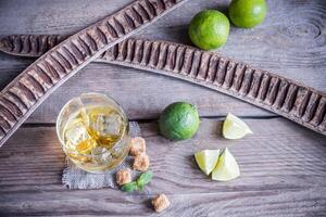 Glass of rum on the wooden background photo