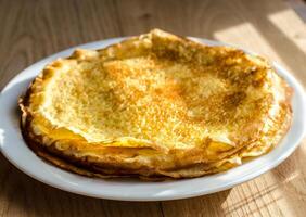 Pile of crepes on the wooden background photo