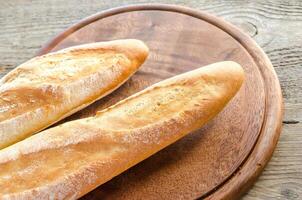 Two baguettes on the wooden tray photo