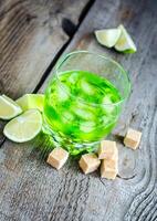 Glass of absinthe with lime and sugar cubes photo