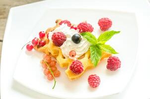 Belgian waffles with whipped cream and fresh berries photo