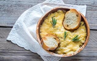 Bowl of onion soup on the wooden table photo