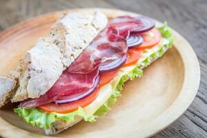 Sandwich with ham, cheese and fresh vegetables photo