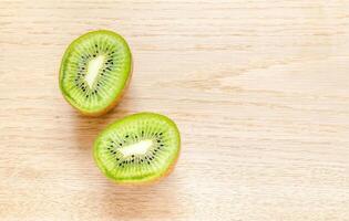 Kiwi on the wooden background whole fruit and cross section photo