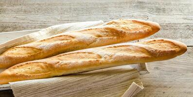 Two baguettes on the wooden tray photo