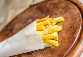 francés papas fritas en un papel envoltura foto