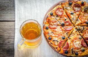 Homemade pizza with a glass of beer photo