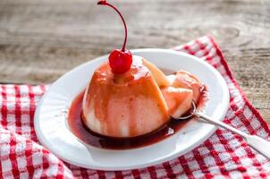 Panna cotta with berry sauce and maraschino cherry photo