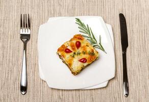 Portion of lasagna on the wooden table photo