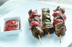 Grilled beef skewers with pepper and brussels photo