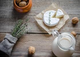 camembert con jarra de leche y nueces enteras foto