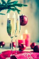 Glasses of champagne under decorated christmas tree branch photo